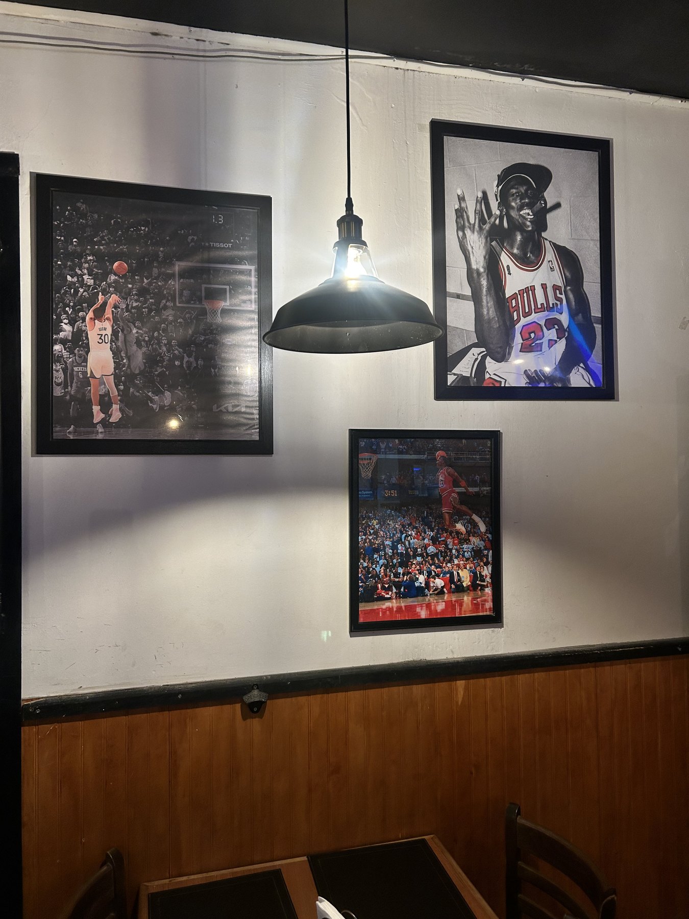 Ambientación interior de Randy's Burger Emmanuel con cuadros deportivos y mesas